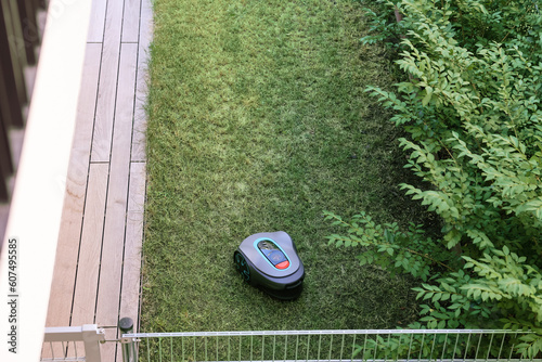 Robotic lawn mower on green grass photo