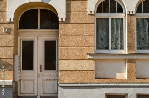 View of residential building with white wooden door, mailboxes and windows