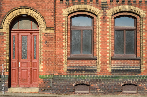 View of brick building with wooden door and windows