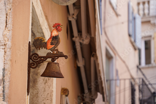 Rooster on the wall. Exterior of residential building decorated by traditional old rooster shaped door bell for ring in street of old town of Rovinj, Croatia