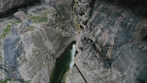 Aerial view of a woman standing on an elevated walkway between two giant rocky walls, Parrizal de Beceite, Rio, Spain. photo