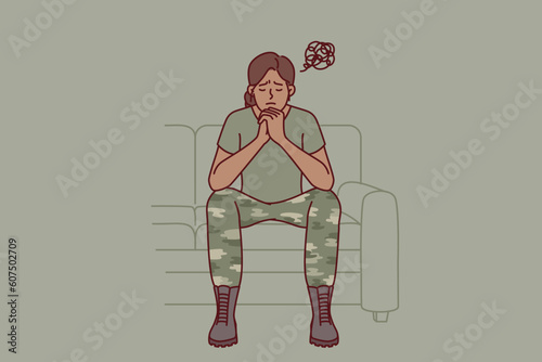 Woman soldier suffers from ptsd caused by bad memories after participating in combat operations. Girl in military uniform of soldier sits on sofa in need of help from army psychologist for veterans