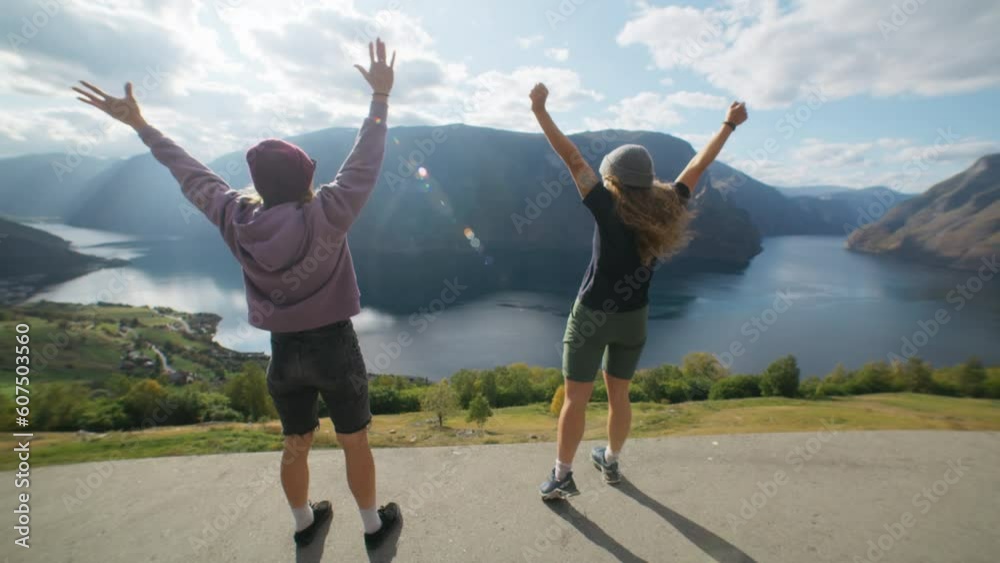 Best friends women run to edge of cliff and celebrate with high five. Concept success and team work. Girlfriends on summer or spring break vacation. Hiking and exploring great outdoors