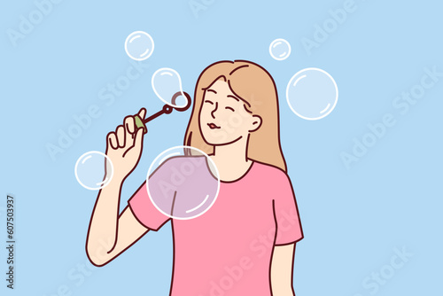 Teenager girl blows soap bubbles enjoying presence free time and absence of urgent matters. Carefree schoolgirl teen stands among soap bubbles and is too lazy to do extracurricular work