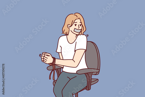 Foto Woman hostage with bound hands sits in chair after being kidnapped or attacked by criminals