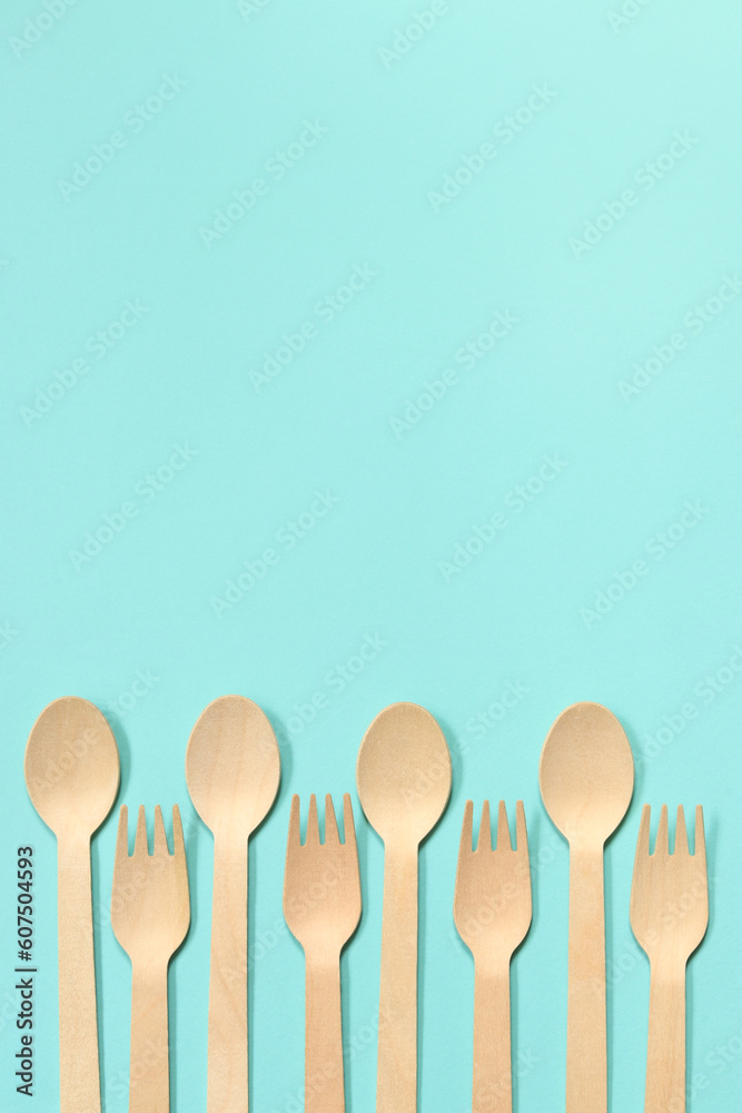 Wooden disposable forks and spoons on a blue background, top view. Eco friendly disposable kitchen utensils, copy space. Flat lay Wooden disposable forks and spoons on a blue background, top view. Eco friendly disposable kitchen utensils, copy space. Flat lay
