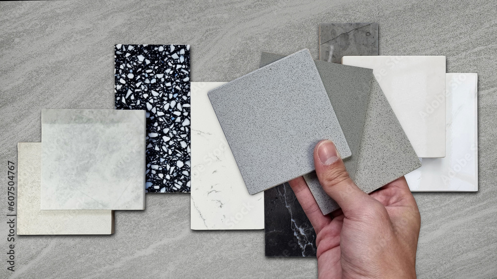interior designer compaing set of grainy quartz samples with black marble, grey artificial stone, terrazzo tiles samples. countertop or tabletop furnishing material samples on travertine background. - obrazy, fototapety, plakaty 