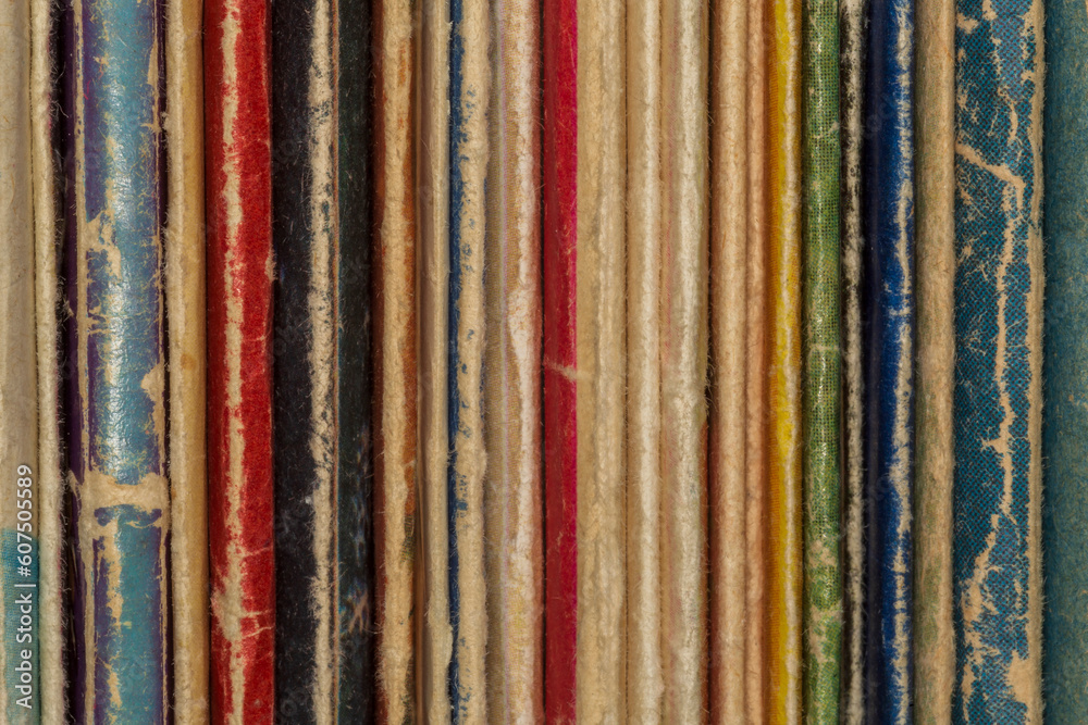 spines of several old shabby books spines of several old shabby books