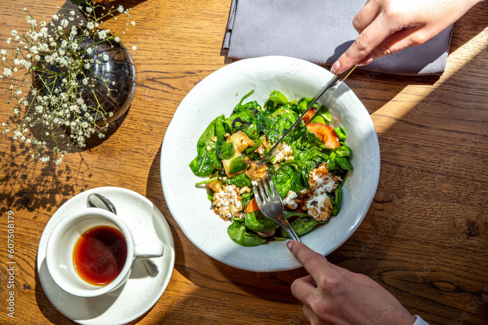 Close-up lifestyle girl in restaurant eat salad with greens, vegetables,  balsamic sauce, on terrace, hands in picture. Healthy lunch, food delivery,  cafe menu. Break for energy, vitamins, refreshness Stock Photo | Adobe
