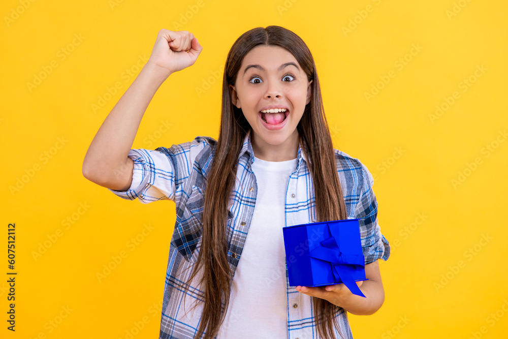 successful teen girl celebrating birthday with present in studio. teen girl holding birthday present box. birthday teen girl posing. Portrait of teen girl with birthday gift isolated on yellow successful teen girl celebrating birthday with present in studio. teen girl holding birthday present box. birthday teen girl posing. Portrait of teen girl with birthday gift isolated on yellow