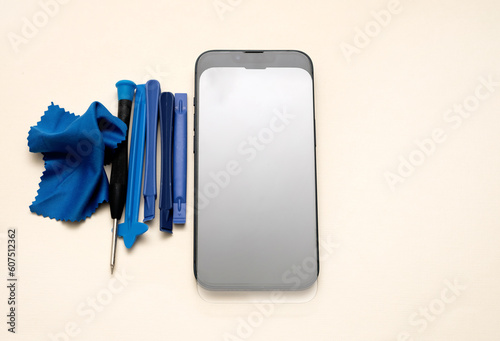 glass film change,repair and maintenance smartphone.hand in glove holding screen protection.flying in air tempered glass and phone.medical stethoscope meaning mobile doctor.tools and display napkin