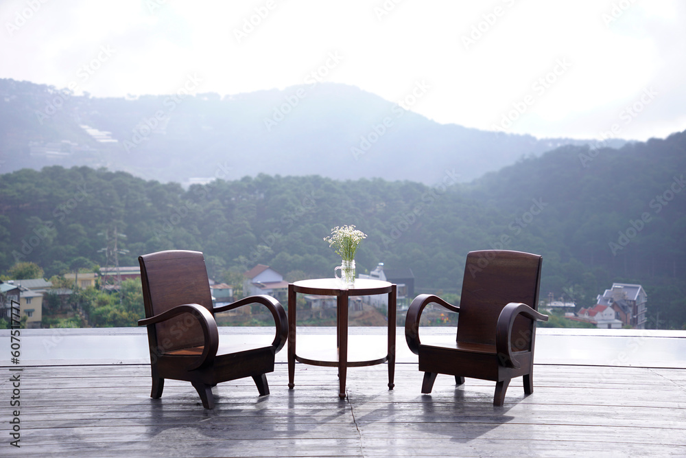 Wooden chairs and table set outdoor with view of mountains