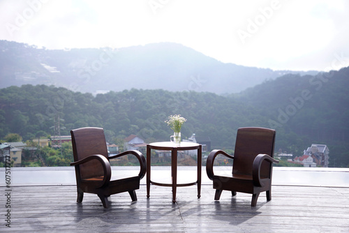 Wooden chairs and table set outdoor with view of mountains © hippomyta