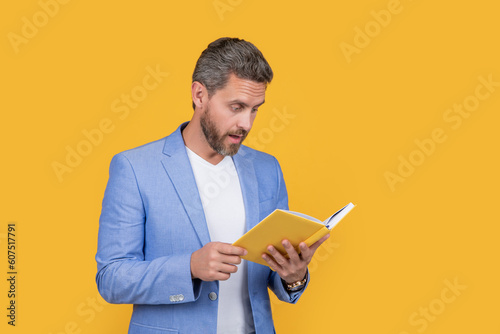 amazed man reader reading book in jacket. studio shot of man reader reading book. photo of man
