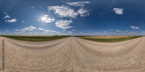 360 hdri panorama on gravel road with clouds and sun on blue sky in equirectangular spherical seamless projection, use as sky replacement in drone panoramas, game development as dome or VR content
