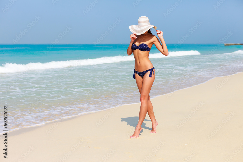 Model tourist woman in bikini on Jumeirah beach, Dubai, UAE Model tourist woman in bikini on Jumeirah beach, Dubai, UAE
