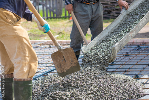 Photography Workers take concrete from the tray to the slab.