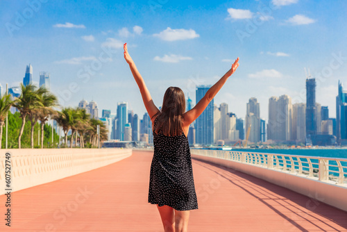 Tourist woman in Dubai, UAE. Palm trees and skyscrapers. Sunny summer