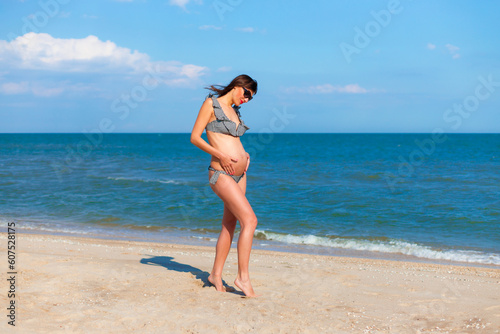 Beautiful pregnant woman on the beach. Happy pregnancy