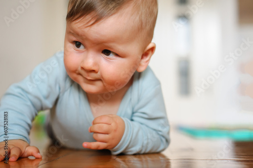 Cute baby boy crawls on the home floor, explore the world and learn to move. Love and family emotion