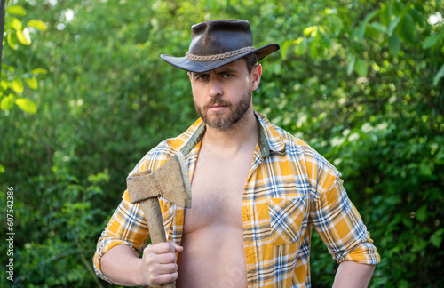 lumberjack with axe wearing unbuttoned checkered shirt. lumberjack with axe outdoor.