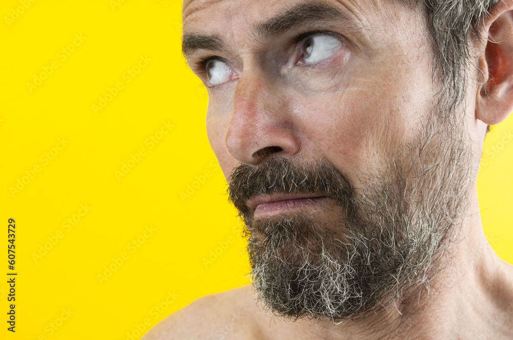Fototapeta premium Portrait of astonished beard man on yellow background
