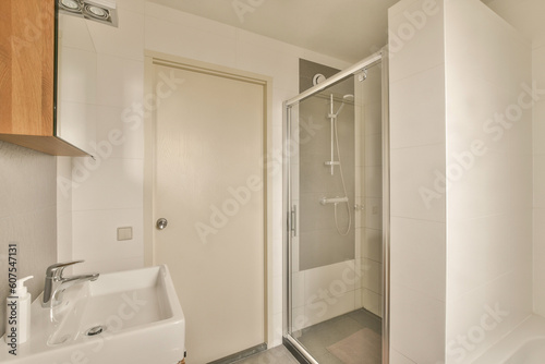 a bathroom with a sink and shower stall in the corner next to the bathtub on the right is an open door