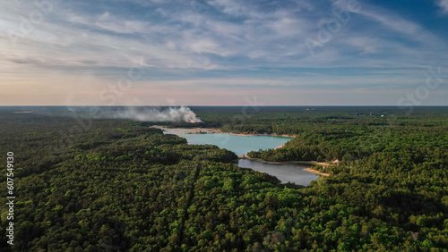 Aerial shot of the blue hole lakes along the Manumuskin river in south New Jersey with a fire burning in the distance.  photo