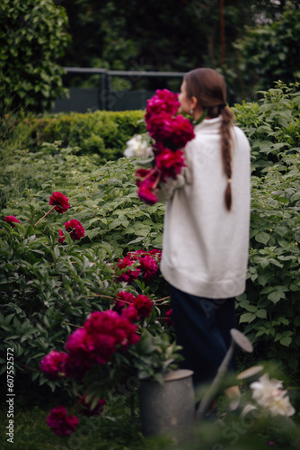 a girl in a flower garden of peonies
