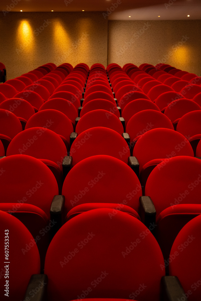 Obraz premium Algumas fileiras de poltronas na cor vermelha em um teatro vazio.