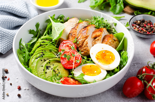 Fototapeta Grilled Chicken Fillet with Fresh Salad, Cherry Tomatoes, Boiled Egg and Avocado, Budha Bowl, Keto Paleo Diet Menu