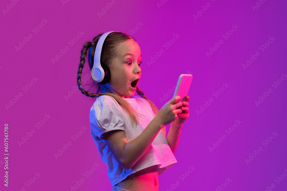 Emotional little girl playing video games on smartphone Emotional little girl playing video games on smartphone