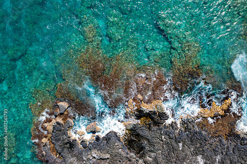 Spectacular Aerial View: Majestic Waves Crashing on Kona's Rocky Coast with Vibrant Reef in Hawaii