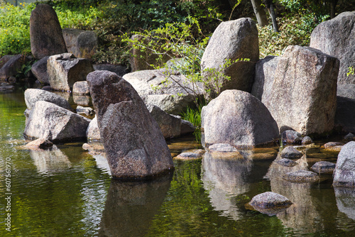 Canvas Print large rocks at a pond of a landscaped Japanese garden