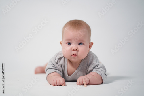 portrait of a baby on a white background. Baby lying on his stomach looking at the camera