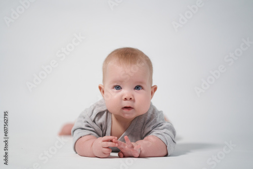 portrait of a baby on a white background. Baby lying on his stomach looking at the camera