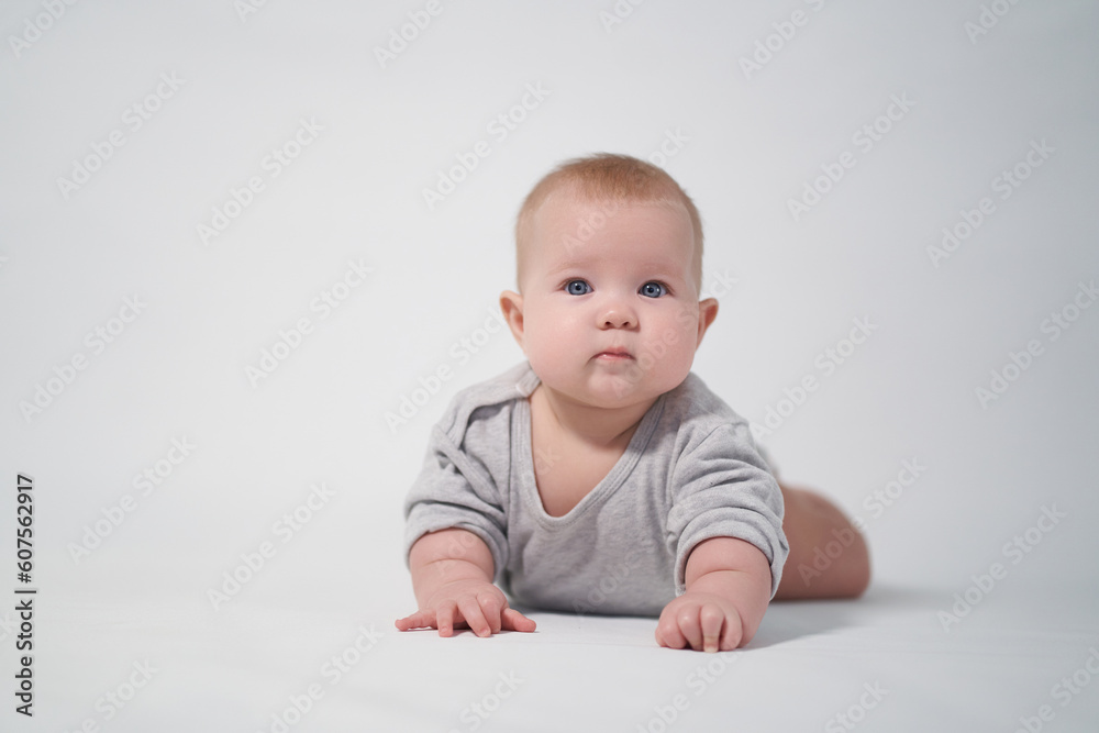 Portrait of a Baby in a gray jumpsuit, the photo was taken in a bright studio Portrait of a Baby in a gray jumpsuit, the photo was taken in a bright studio