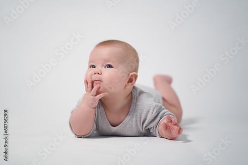 portrait of a baby with a thoughtful face looking into the camera at the operator, the photo was taken against a light background