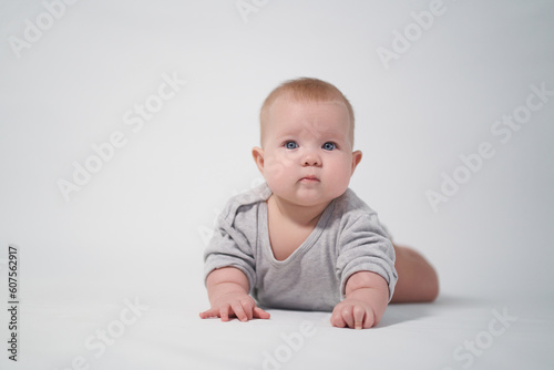 Portrait of a Baby in a gray jumpsuit, the photo was taken in a bright studio