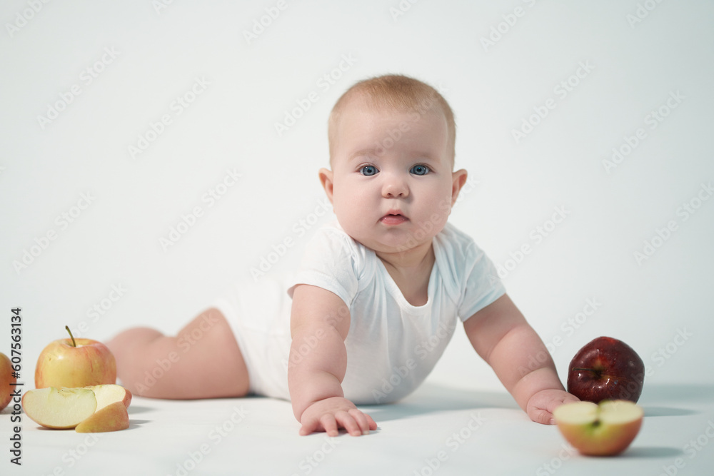 Newborn baby photo on a light background among apples Newborn baby photo on a light background among apples
