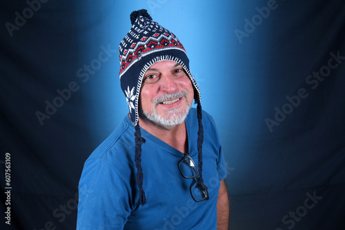 happy bald man with white beard Peruvian cap on his head looking forward with good expression