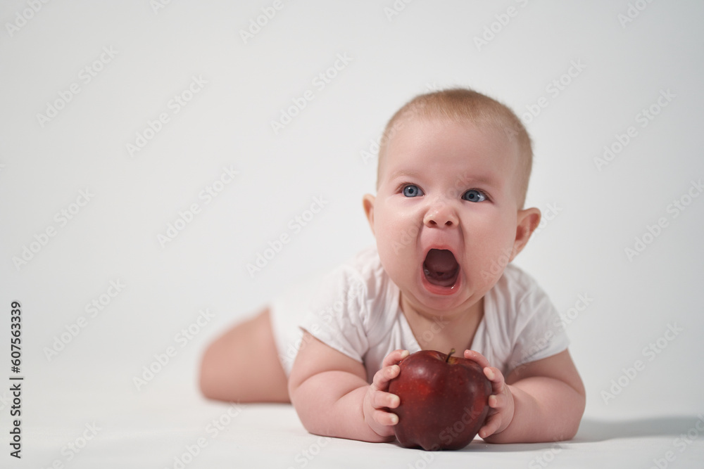 Baby 7 months old with a red apple in his hands Baby 7 months old with a red apple in his hands