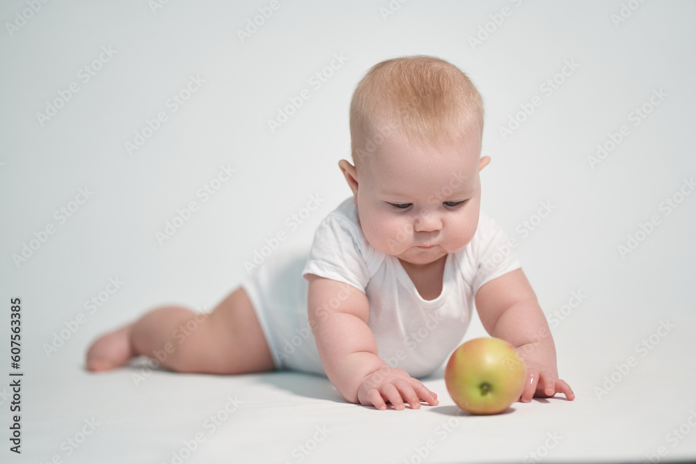 Baby 7 months old with an apple. photography on a white background Baby 7 months old with an apple. photography on a white background