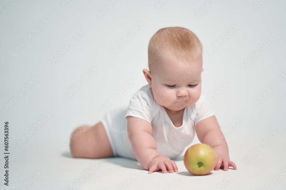 Baby 7 months old with an apple. photography on a white background Baby 7 months old with an apple. photography on a white background