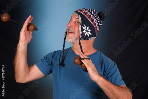 happy bald man with white beard Peruvian cap on his head playing musical instrument asalato looking forward with good expression photo
