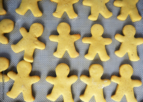 ready-made gluten-free gingerbread cookies in the form of gingerbread men lie on parchment paper. view from above . homemade baking . kitchen . the process of making sweets on a diet