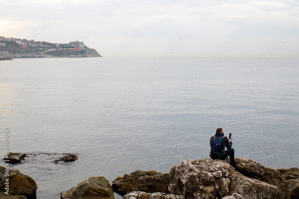 Person sitting by the sea watching the sea