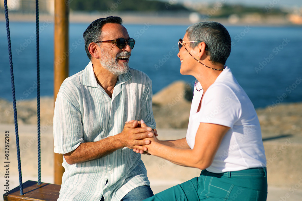 Mature Spouses Enjoying Vacation At Sea Sitting On Swings Outside Mature Spouses Enjoying Vacation At Sea Sitting On Swings Outside