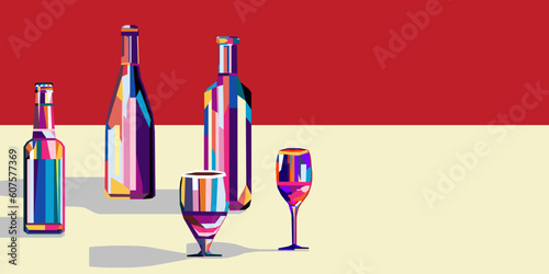 Various multi-colored bottles with wine and beer and a glass next to them. There is a copy space nearby.