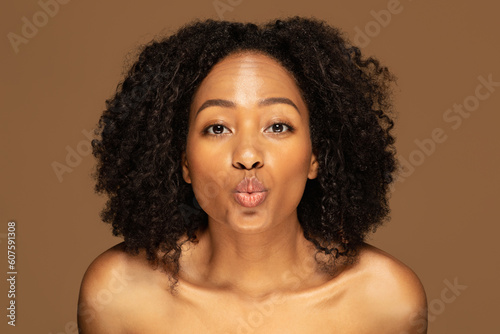 Closeup of playful topless young black woman showing kissing lips